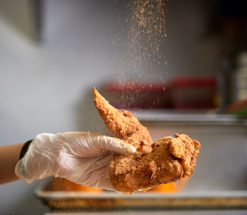 Spicing a piece of chicken