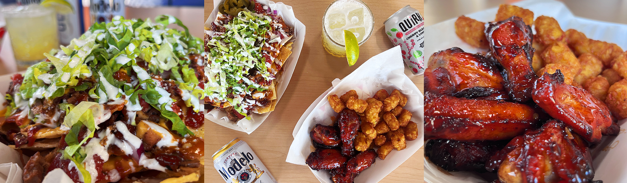 Aerial view of food on a blonde wood table. Nachos with a cream sauce drizzled on top, hot wings, and a can of beer.